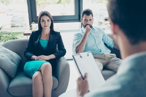 Serious couple is listening to their family doctor, concentrated and anxious, sex, pregnancy, cheating, mistrust domestic  problems concept
