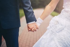 Newlywed couple holding hands