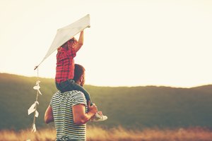 happy family father and child on meadow with a kite