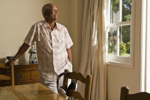 Pensive senior man looking at window