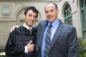 Smiling graduate and man embracing