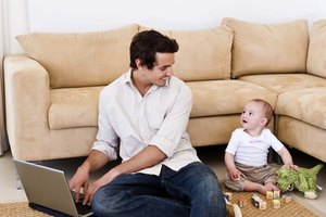 Father and son on floor with laptop computer and toys