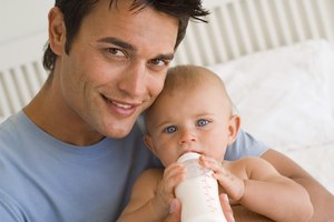 Father bottle feeding baby