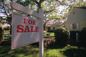 For sale sign hanging in front of house