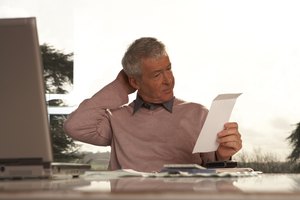 Man sitting at desk scratching head