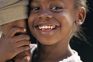 Smiling girl clinging to arm of parent