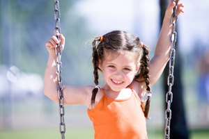Smiling girl on swingset