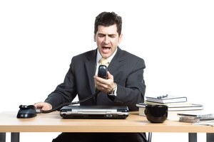 Businessman yelling at telephone