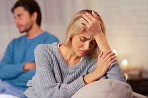 Depressed Wife Sitting Next To Indifferent Husband At Home, Panorama